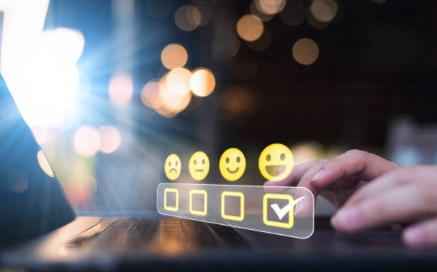 istock Concept for a customer satisfaction survey showing a businessman selecting a smiley face icon with five yellow stars to rate a product or service. 1465478099