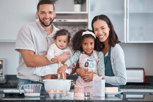 Happy family, baking and learning while teaching girl to bake in kitchen counter, love and fun together in home. Dad, mom and girl kids or baby with food, ingredients and flour for breakfast in home