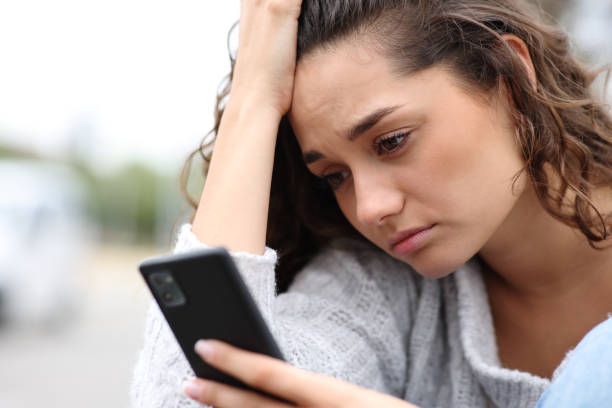 Sad woman checking phone message stock photo