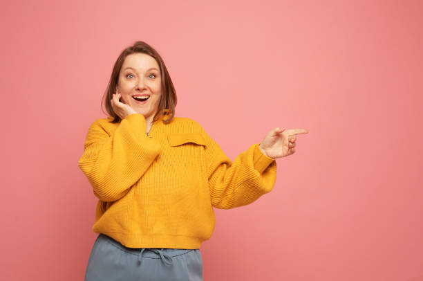 istock young woman pointing with finger at blank copy space aside 1465483498