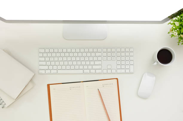 istock Top view of a minimal white office desk workspace with computer and book with empty pages. 1465485120