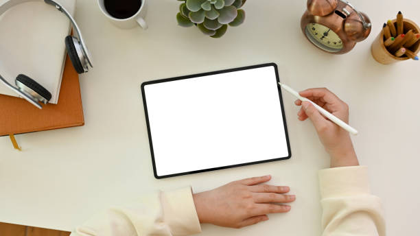 istock A female using a digital tablet, designing her artwork, working at her minimal white office desk. 1465485135