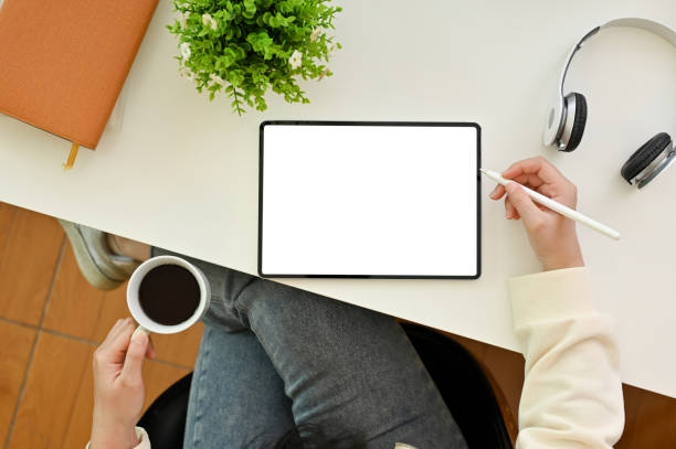 istock Top view, A female graphic designer working, using digital tablet and sipping coffee at her desk 1465485184