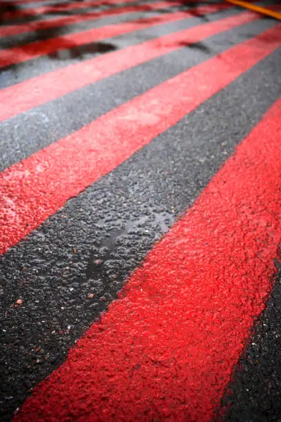 Photo of Road marking for fire tracks parking. abstract background of red and white markings for fire fighting equipment on wet pavement