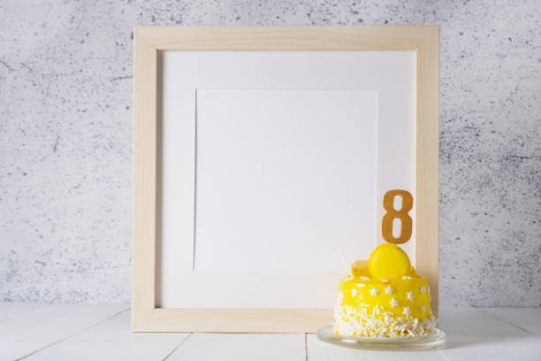 istock The number Eight on the yellow cake next to the white frame mockup with copy space. 1465486192