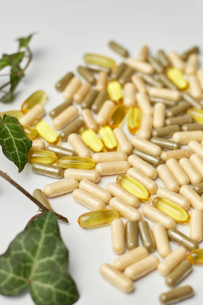 istock Pills, medical tablets with green plants, leaves on white background 1465487814