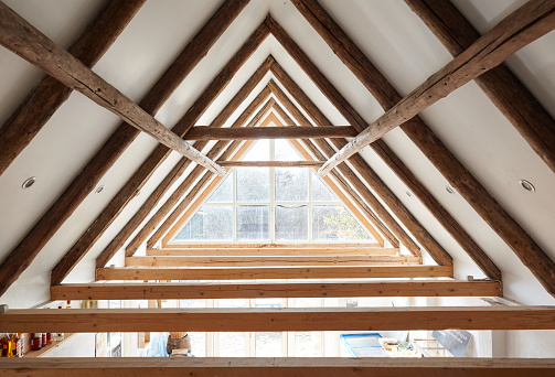 Very authentic architecture of a ceiling/attic, with visible brown frameworks, a big window makes it very bright and luminous. Huge ceiling high.
