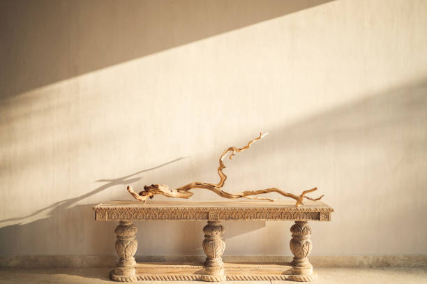 istock Driftwood branch sculpture on a carved console table by the beige wall 1465489325