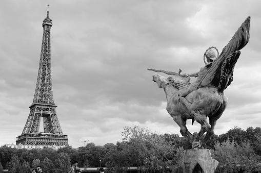 Paris, France – October 13, 2022: A grayscale shot of the France Reborn statue with a background of the Eiffel Tower