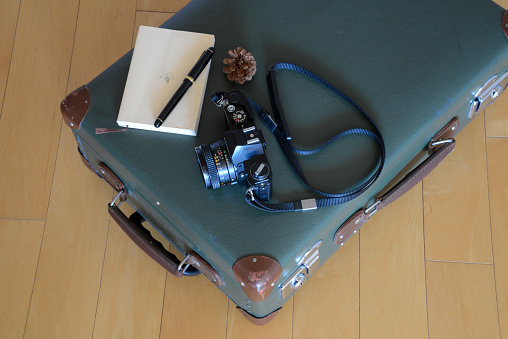 A close-up picture of a young Caucasian businessman holding a modern suitcase in his hand, while on a business trip.