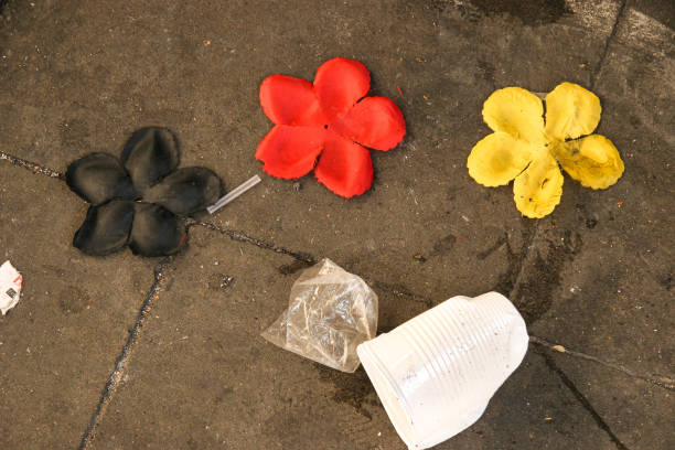 Three plastic flowers in black, red and gold lie on the floor between plastic pans