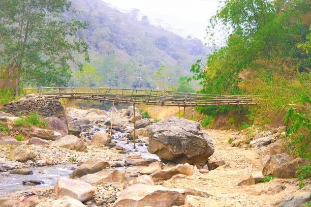 istock Large Boulder Rocks and river streams flowing in a mountain valley against hill, forest, and a Bamboo bridge in the background. Rangbang river mountain valley. Tabakoshi West Bengal India 1465497496