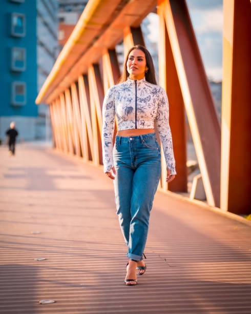 istock Attractive brunette female walking along a bridge and posing during the sunset 1465497513