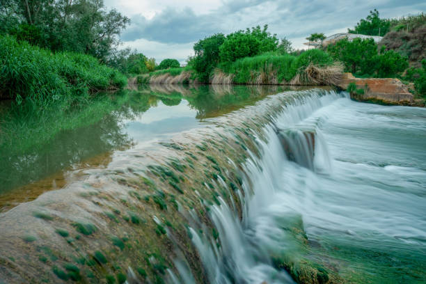 istock Closeup shot of a waterfall surrounded by reeds and trees 1465497571