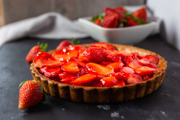 nahaufnahme einer köstlichen erdbeertorte auf schwarzem hintergrund - strawberry tart stock-fotos und bilder