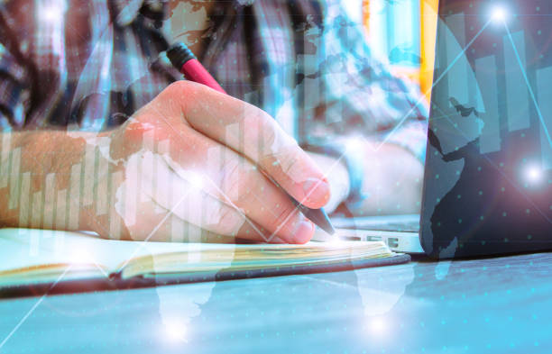 istock Businessman typing next to a computer with graphics overprinted -stock exchange concept 1465498682