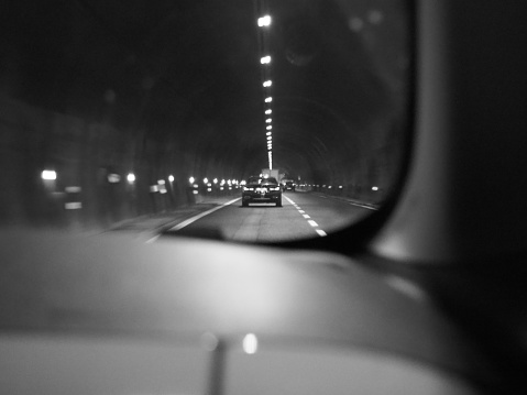 The grayscale of car driving in tunnel