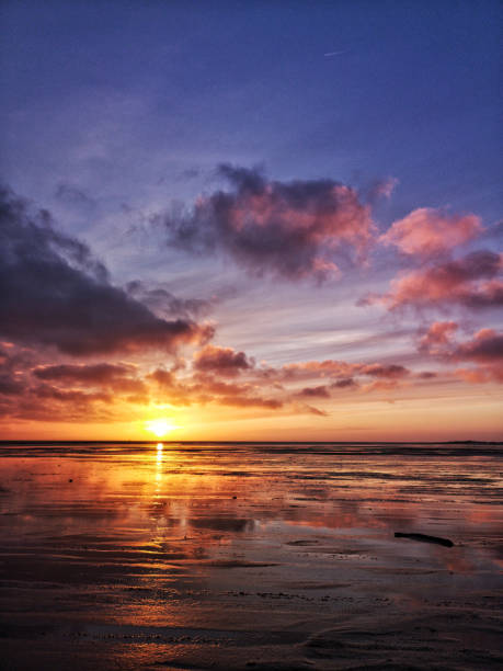 istock Vertical shot of a beautiful seashore under a sunset sky 1465500393