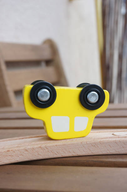 Yellow wooden toy car on a track