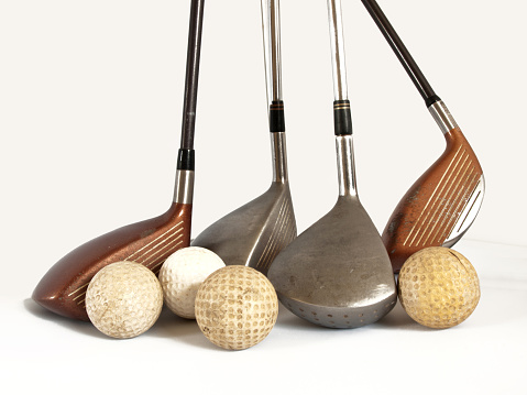 antique golf balls and old  clubs
