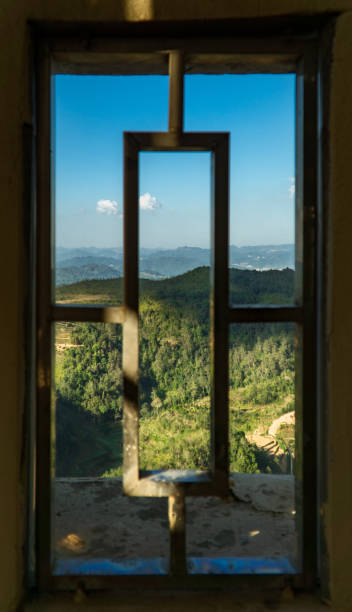istock Vertical shot of old rusty window frames with mountains and greenery in the background 1465501498