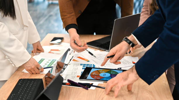 istock Business meeting in an office, workers discussing business affairs using gadgets and papers with charts 1465501904