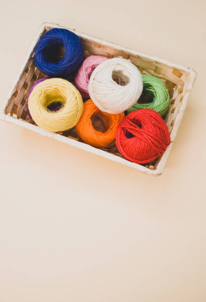 istock Vertical shot of colorful thread rolls in a box isolated on a beige background 1465503776