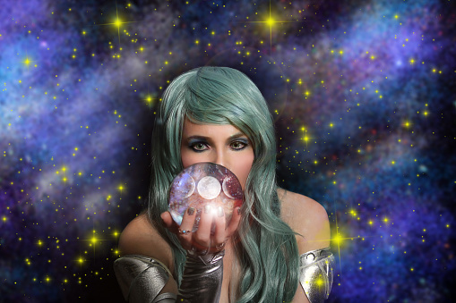 A closeup of the psychic woman with green hair holding the crystal ball in front of her face.