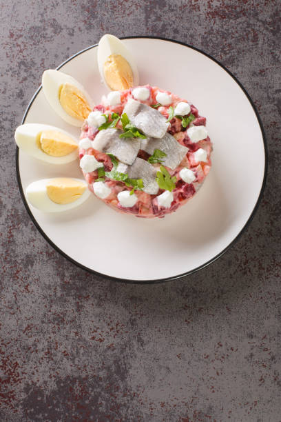 Herring salad or Sillsallad traditional dish of Scandinavian cuisine close-up in a plate. vertical top view Herring salad or Sillsallad traditional dish of Scandinavian cuisine close-up in a plate on the table. vertical top view from above vujovich stock pictures, royalty-free photos & images