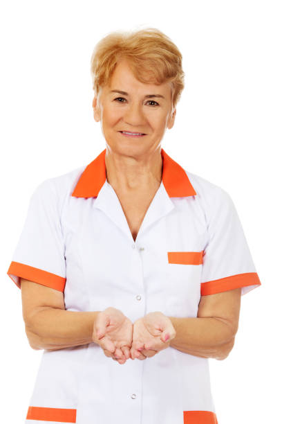An elderly female nurse presenting something on open palms