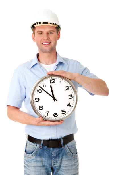 istock Vertical shot of man in helmet holding a clock 1465510789