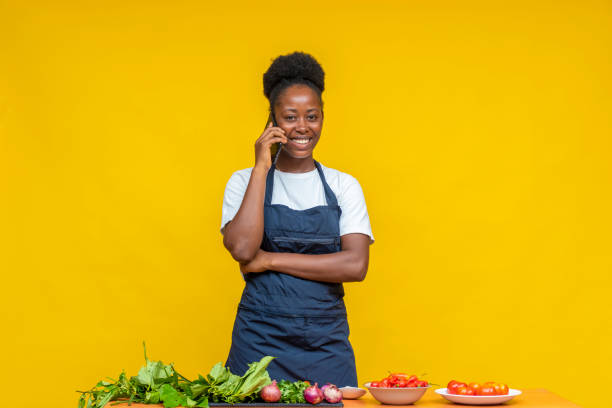 istock African female chef making a call while preparing food in front of a yellow wall 1465511775