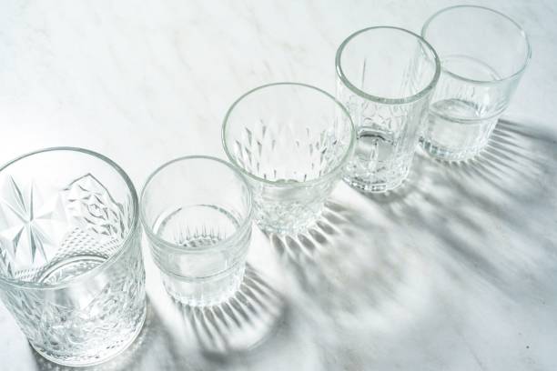 istock Top view of Empty glasses cups on white surface with bright light 1465512145