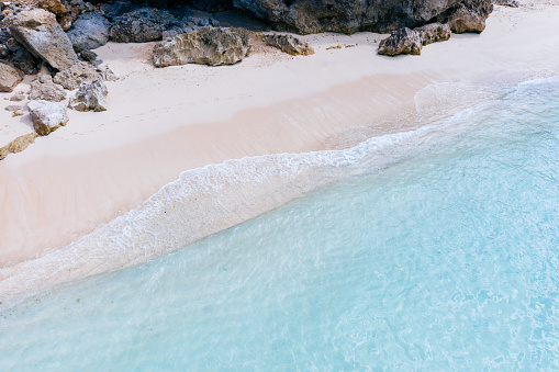 Beach scene - turquoise transparent ocean and  white sand beach. Bali, Melasti beach aerial view.