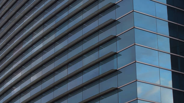 istock Modern building with glass windows reflecting the blue sky 1465512855