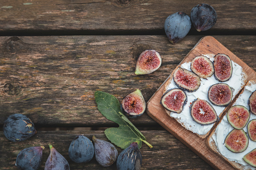 The Cream cheese sandwich with figs served on wooden board with copy space