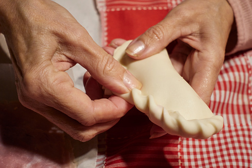 The woman's hand preparing Argentine repulgue empanadas