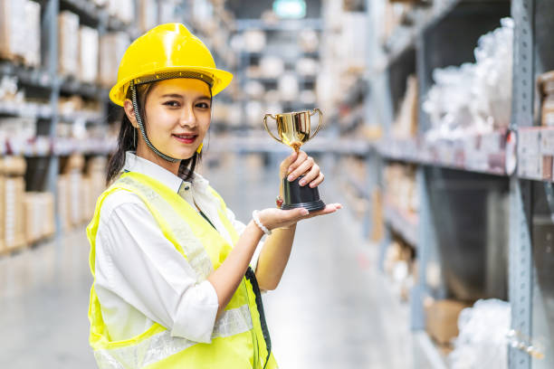 istock Happy woman warehouse worker holding a trophy after being select 1465514865