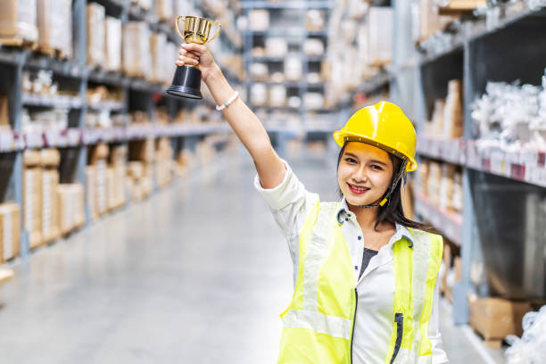 istock Happy woman warehouse worker holding a trophy after being select 1465514899