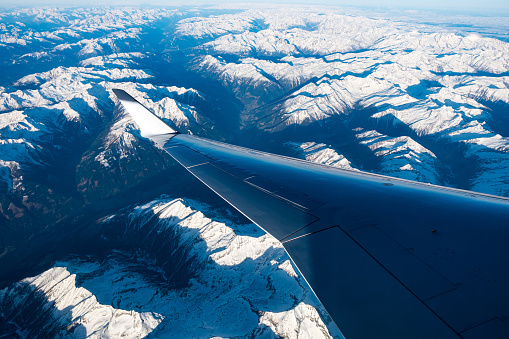 A breathtaking view of the snow-capped mountain landscape from the airplane