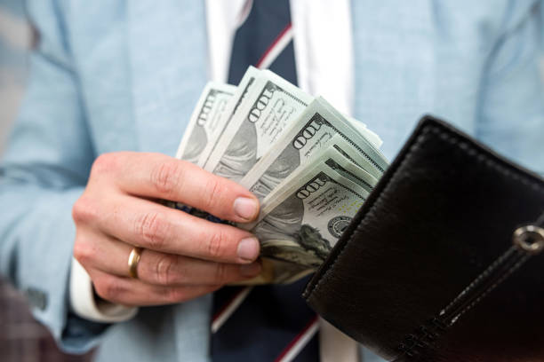 istock Businessman hands holding black leather wallet with dollar bills 1465517857