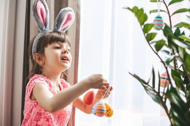 istock Little girl decorating a plant for Easter holiday 1465518681