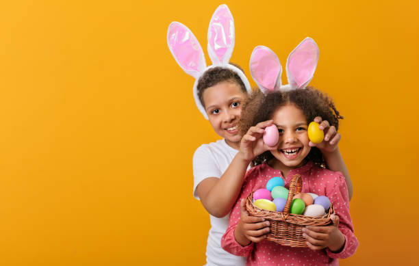 istock A happy children with rabbit ears on her head with a basket full of Easter eggs 1465518744