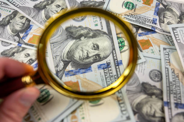 istock closeup of 100 US Dollar banknotes under magnifying glass 1465518981