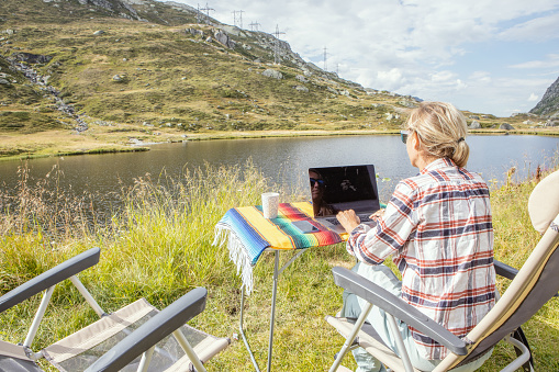Woman using laptop working remotely in nature