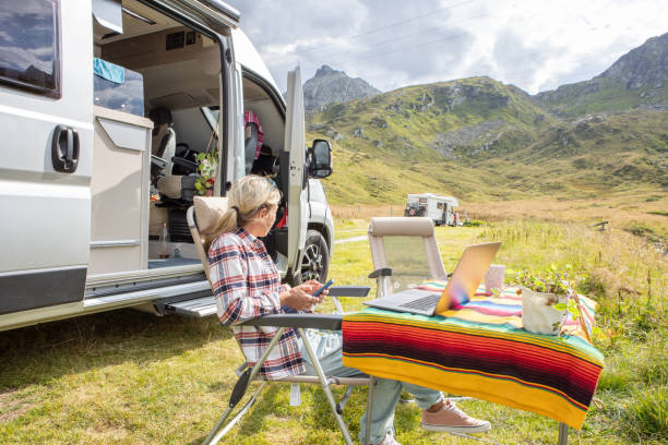 istock Woman travelling by van, working remotely with her laptop 1465523382