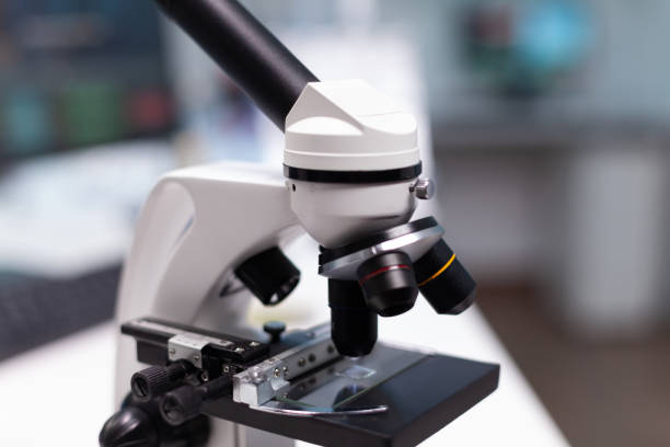 istock Close up of microscope with transparent tray in science laboratory 1465523587