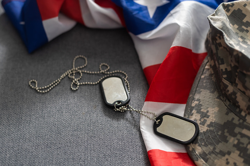 Army tokens on military uniform and USA national flag background