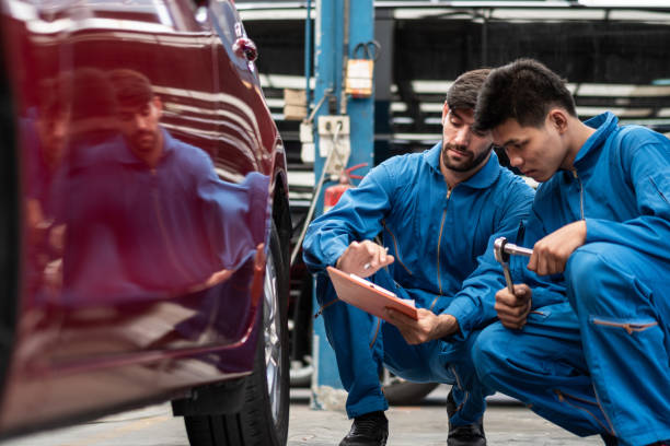 istock automotive mechanic men checking at car tyre rubber condition needed for replacement, man pointing hand at wheel following maintenance checklist document, after service at auto repair shop concept 1465529813