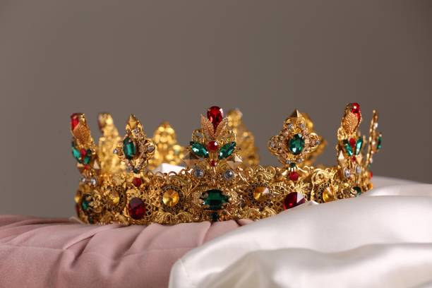 istock Beautiful gold tiara with gems on pink and white cloth 1465533351